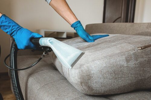 hand in protective rubber glove cleaning sofa in Asheboro NC